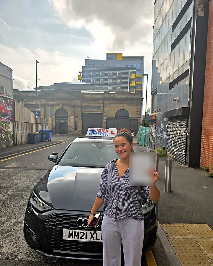 Astra Driving School student holding their driving test pass certificate