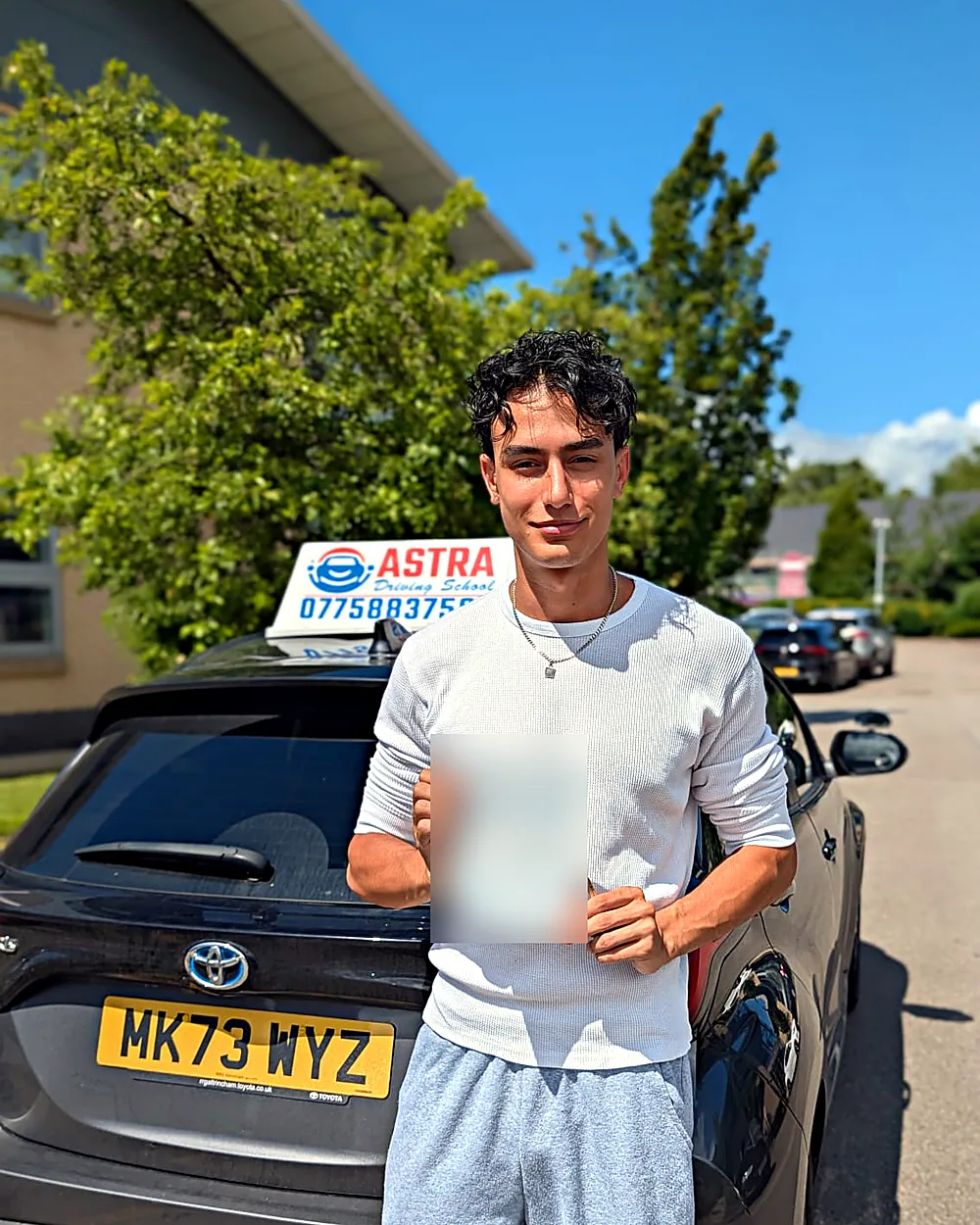 Astra Driving School student holding their driving test pass certificate