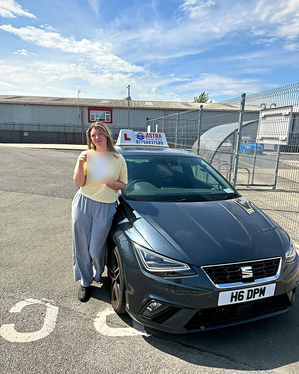 Astra Driving School student holding their driving test pass certificate