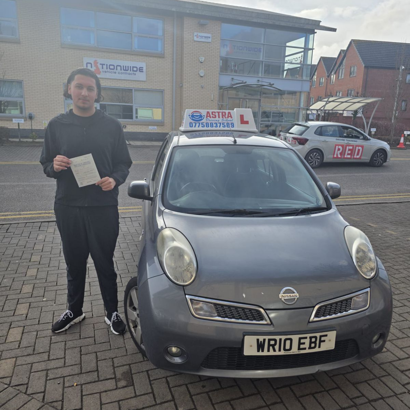 Astra Driving School student holding their driving test pass certificate