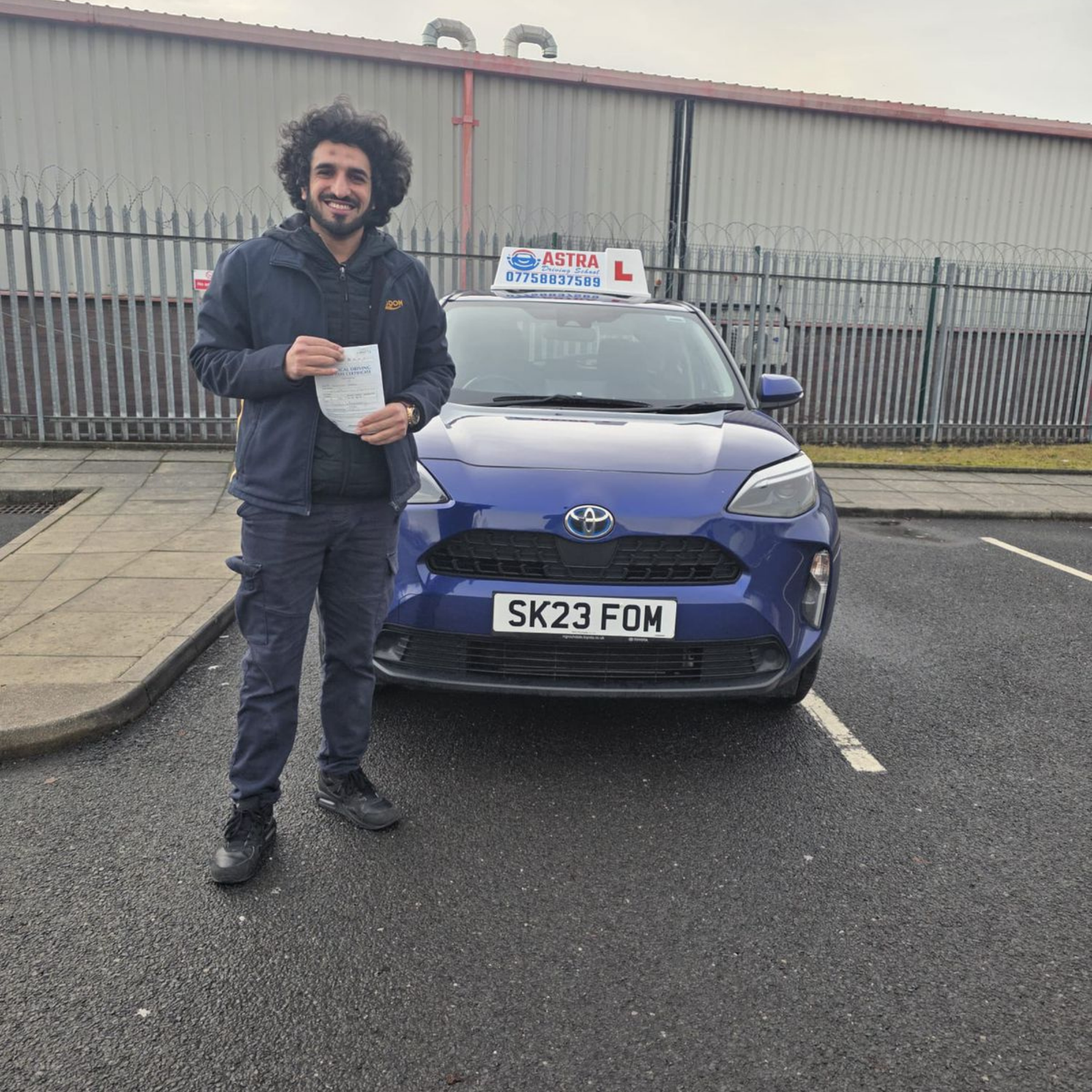 Astra Driving School student holding their driving test pass certificate