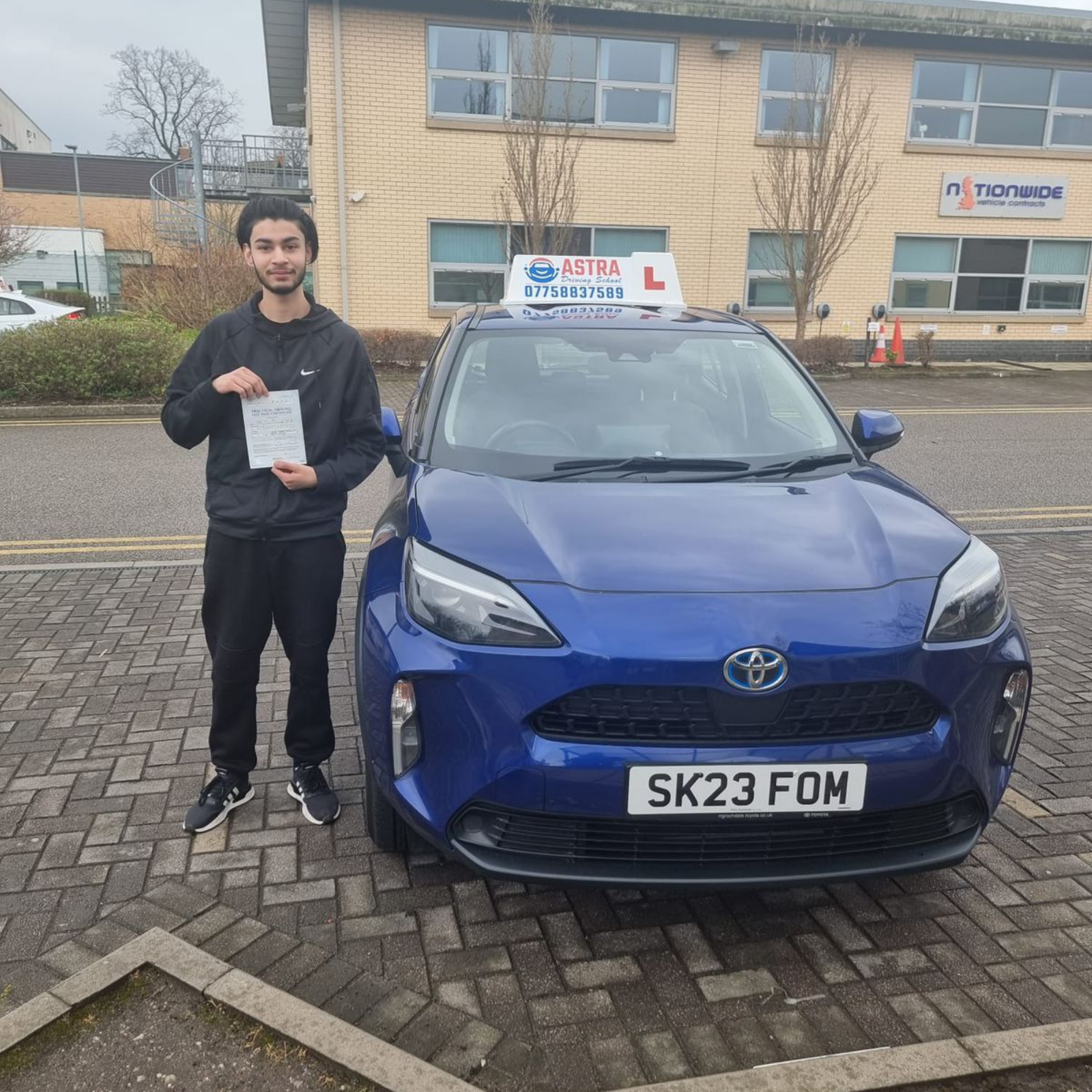 Astra Driving School student holding their driving test pass certificate